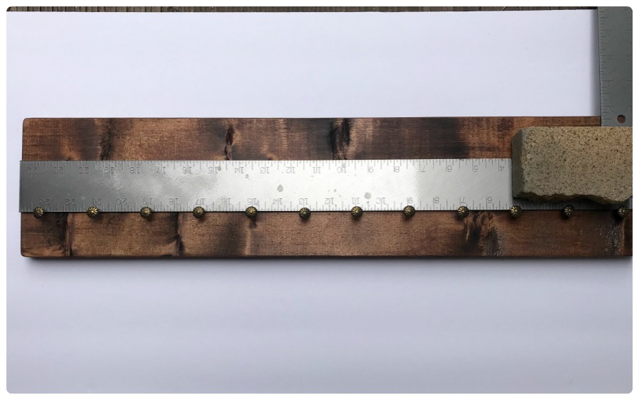Using the ruler to place the furniture nails.