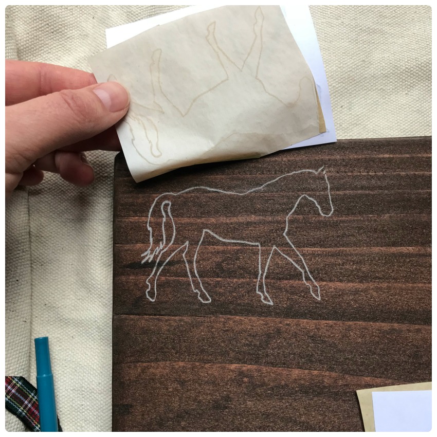 Using transfer paper to draw horses on the bench