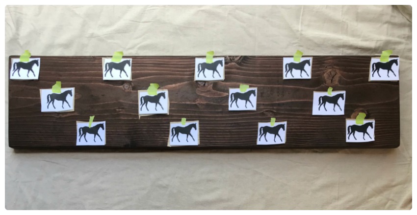 Arrange the horses with the transfer paper underneath the horse. The white transfer paper should be touching the wood.